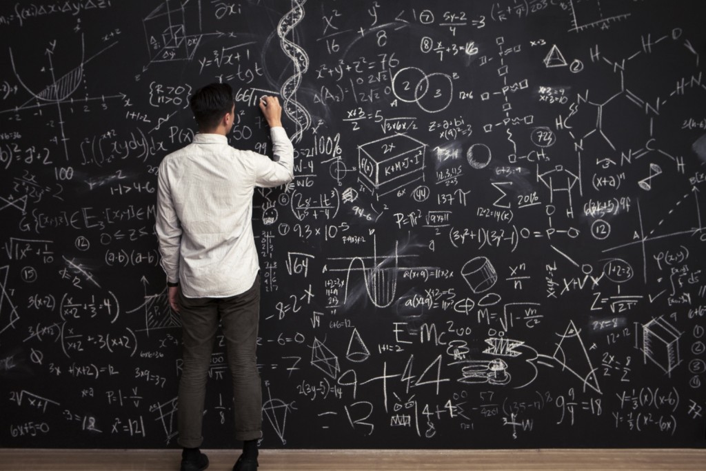 Man writes mathematical equations on chalkboard